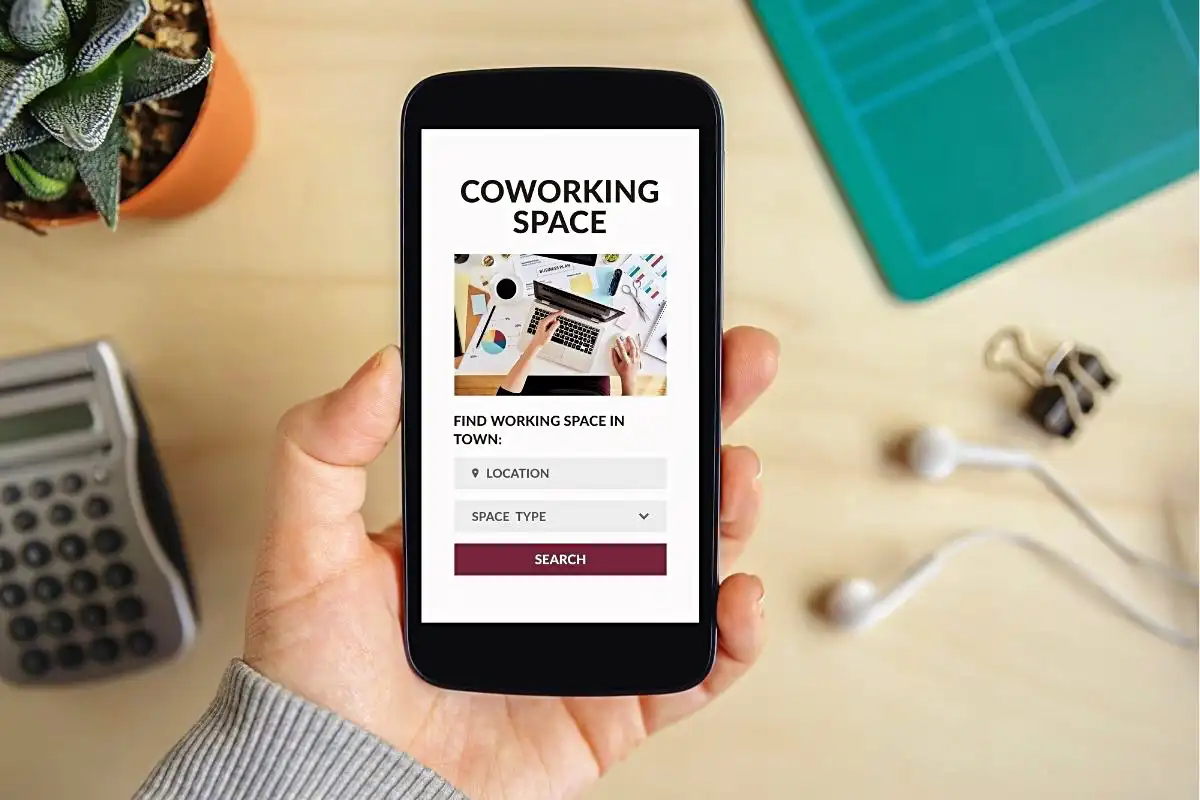 Mobile phone with a co-working space app - Happy Mind Training Blog | Why People Thrive in Coworking Spaces