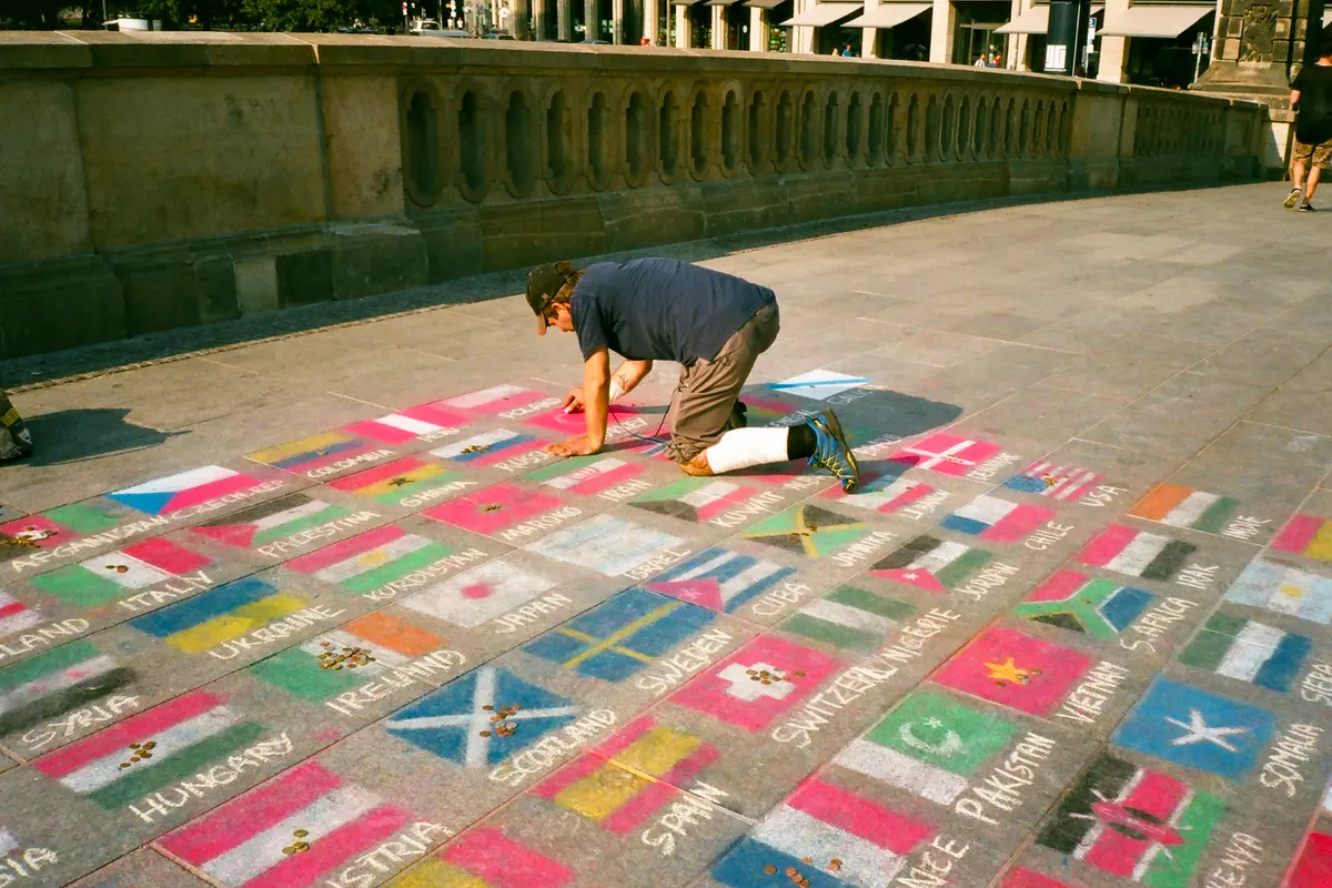 Man chalk drawing flags on the pavement