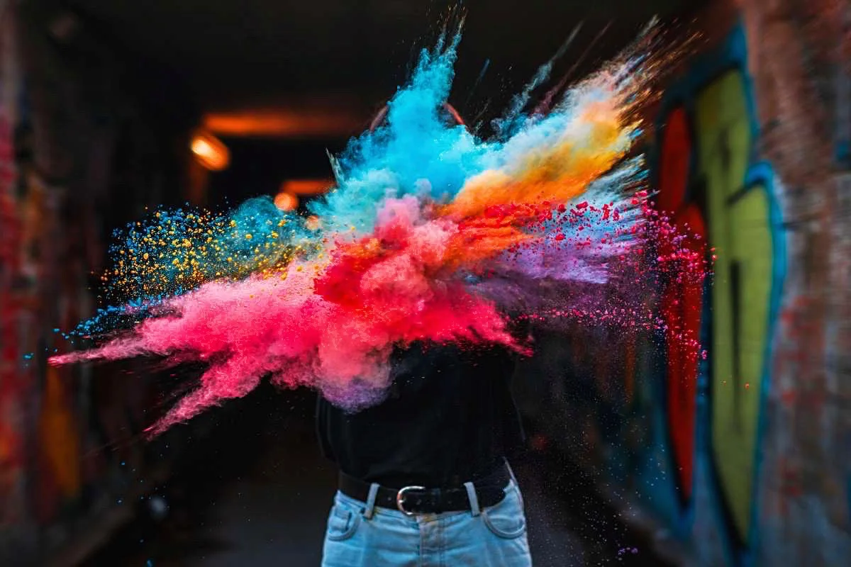 Beautiful multicoloured powder exploding in front of a person