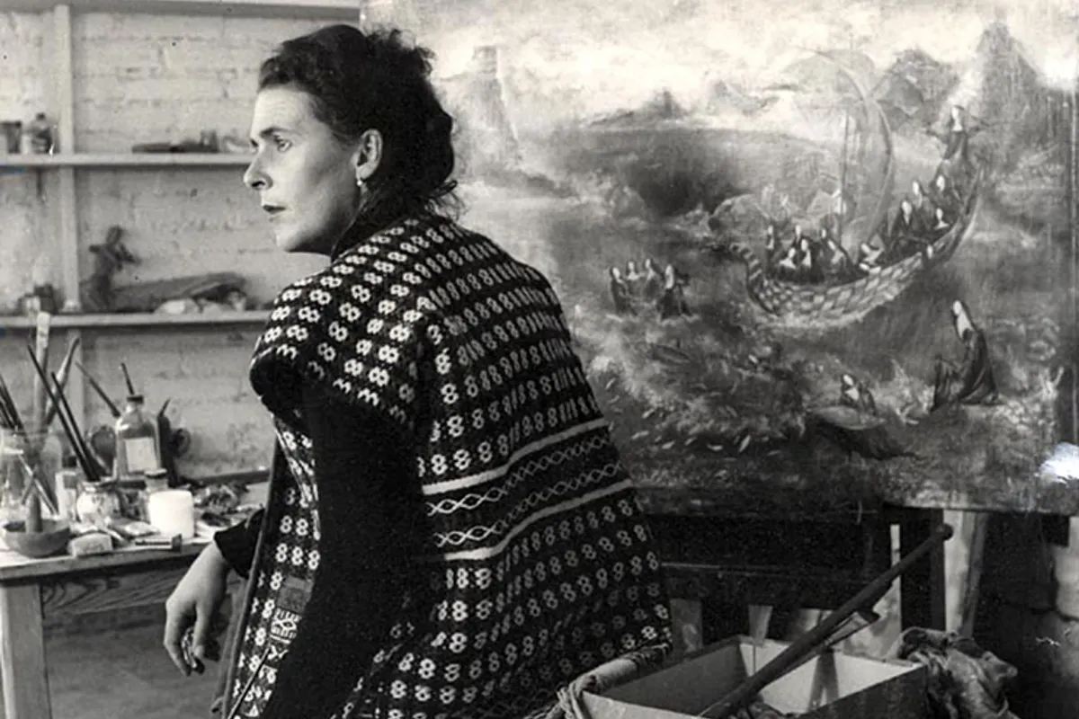 Female artist sat in art studio in front of her artwork