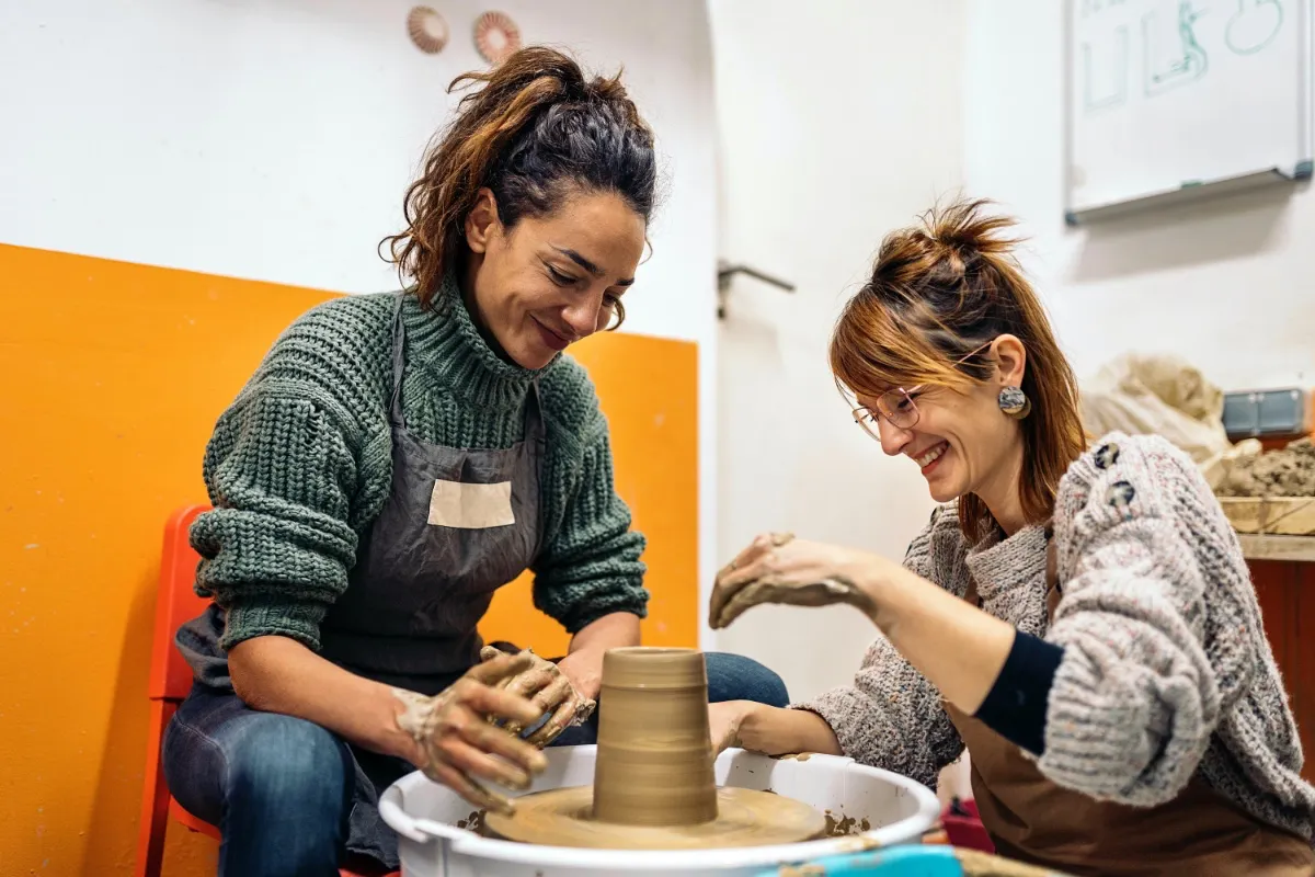 Happy Mind Training Blog | Healthy Hobbies - Two women smiling using pottery wheel