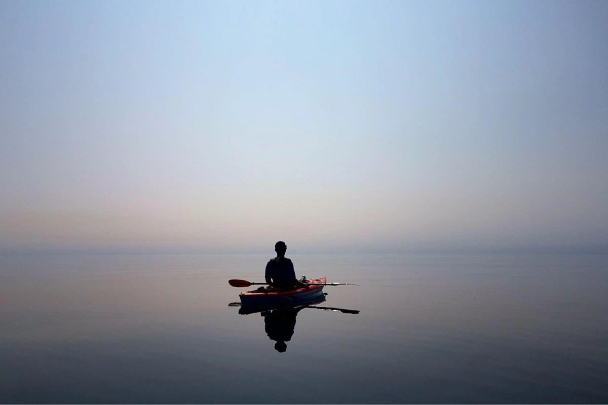 Person kayaking on a calm body of water | HappyMind Training Blog | Recognising Stress