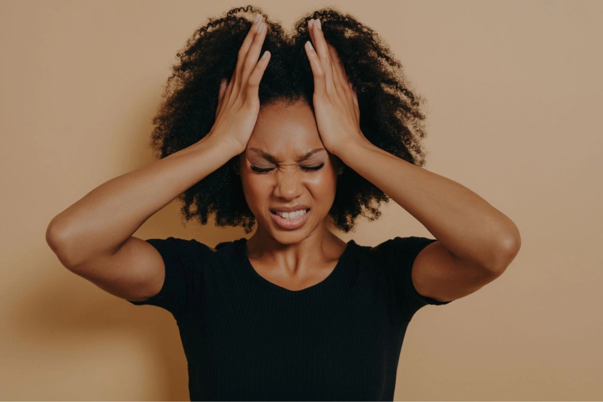 Stressed woman pulling her face back | HappyMind Training Blog | Recognising Stress