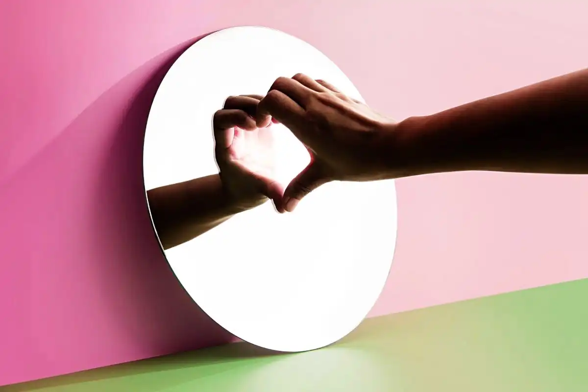 Hand making a heart shape using its reflection on a mirror - Happy Mind Training Blog | 7 Ways Owning Your Mistakes Will Make You Powerful