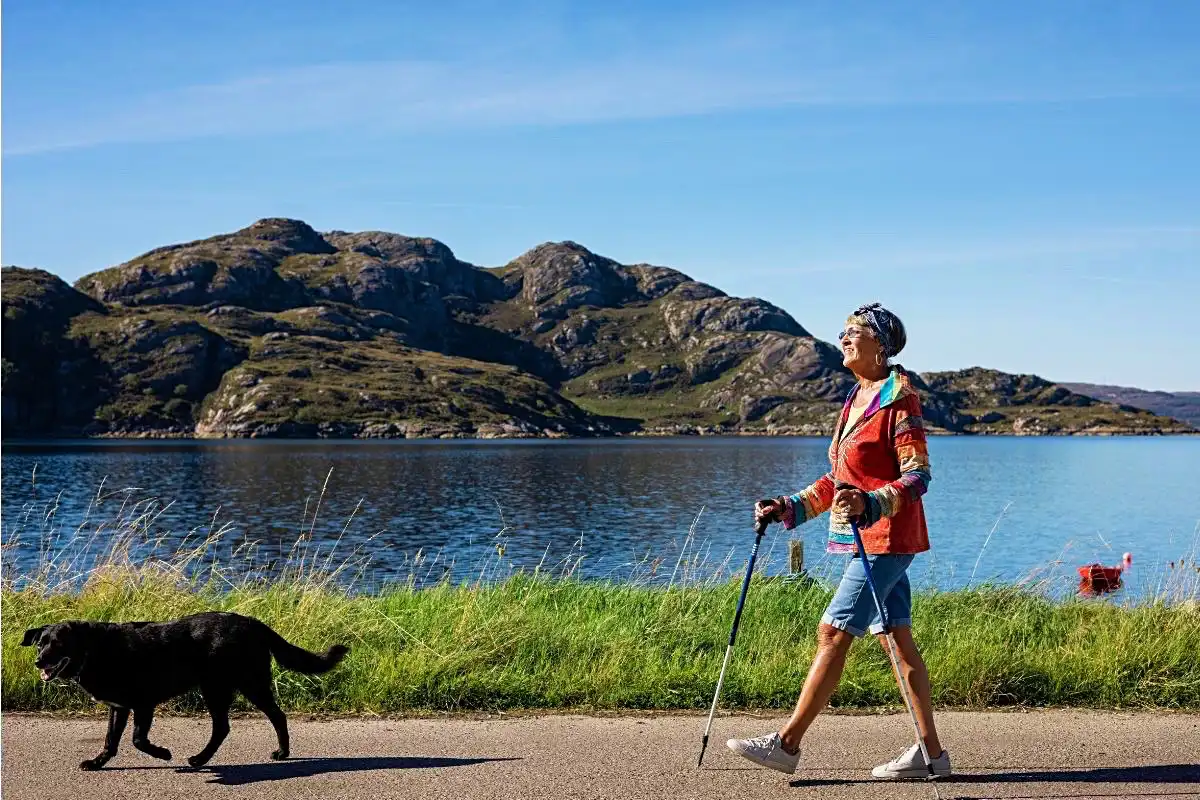 Person walking with their dog near a lake - Happy Mind Training Blog | Simple Mindfulness Practices